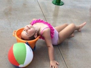 splash park little girl with head in bucket